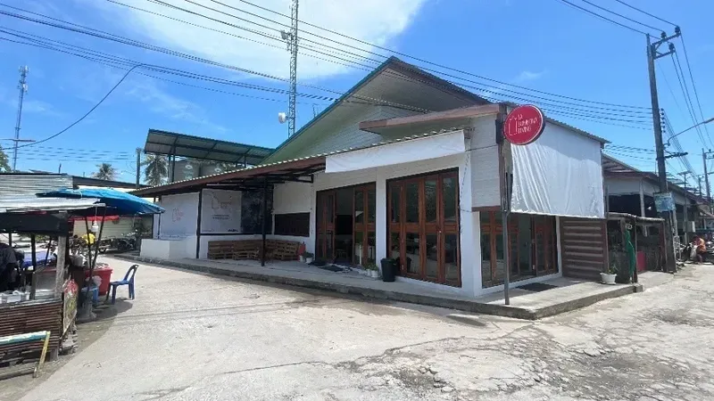 Façade d'un bâtiment blanc avec des personnes assises à l'extérieur