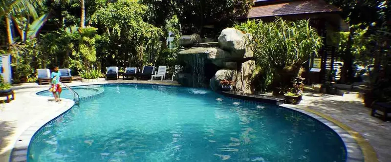 Piscine d'un centre de plongée avec des transats et végétation tropicale