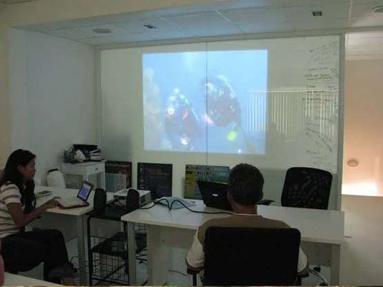 Cours de plongée en salle avec projection d'images sous-marines et ordinateurs