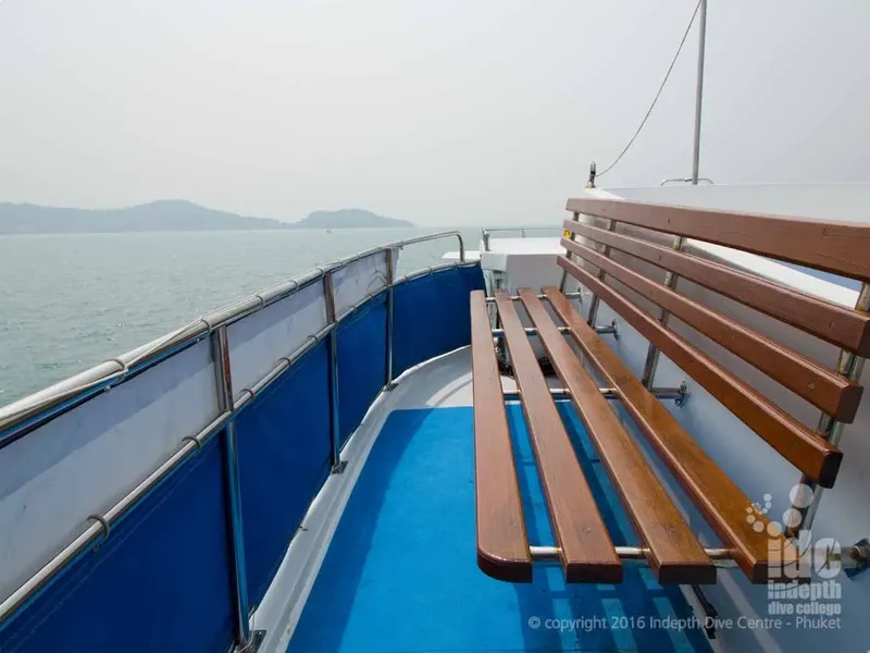 Vue de l'avant d'un bateau de plongée avec des bancs en bois bleus