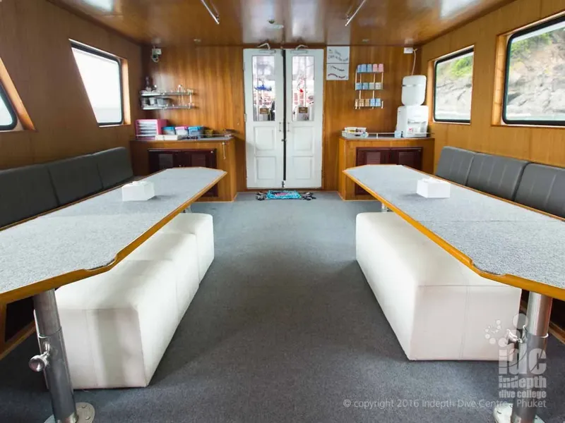 Intérieur d'un bateau de plongée avec des bancs et des rangements