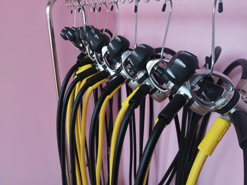 Rangée de détendeurs noirs et jaunes suspendus sur un support