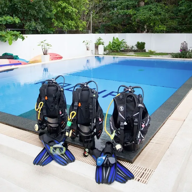 Equipement de plongée complet aligné près d'une piscine bleu turquoise