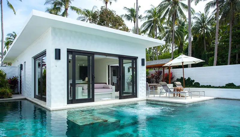 Bâtiment blanc moderne avec piscine et mobilier de jardin extérieur