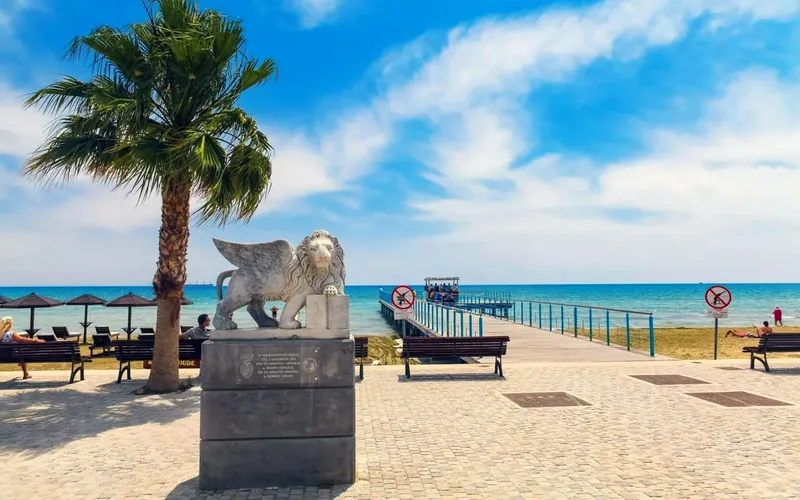 Vue d'une promenade en bord de mer avec statue et personnes assises