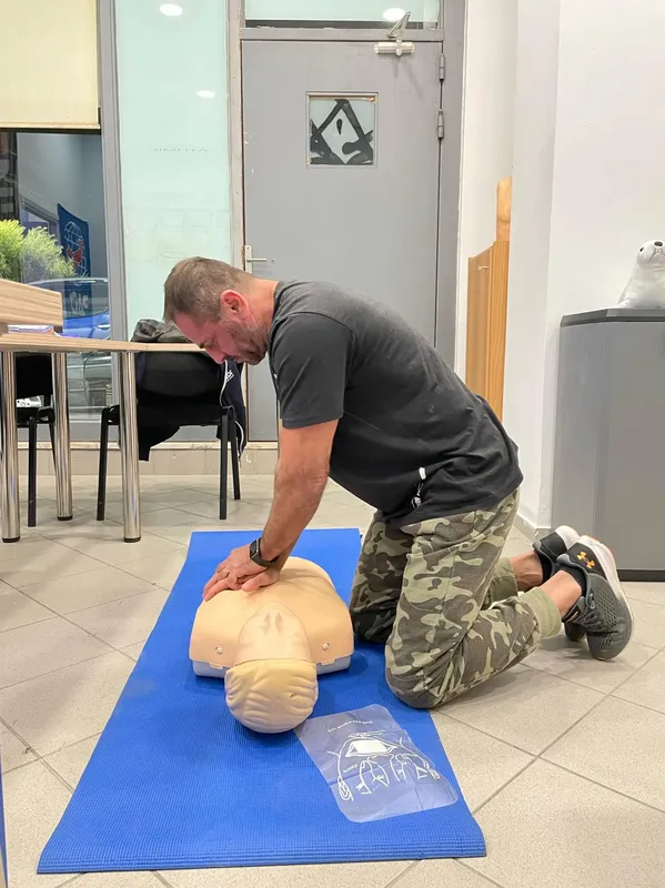 Un homme effectue un massage cardiaque sur un mannequin d'exercice