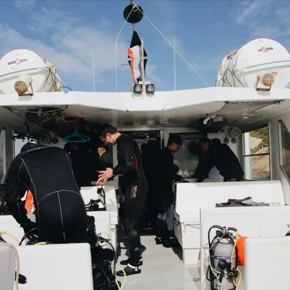 Plongeurs s'équipent à bord d'un bateau blanc avant une sortie