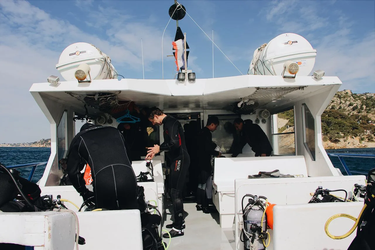 Plongeurs s'équipent sur un bateau blanc en mer, préparation plongée