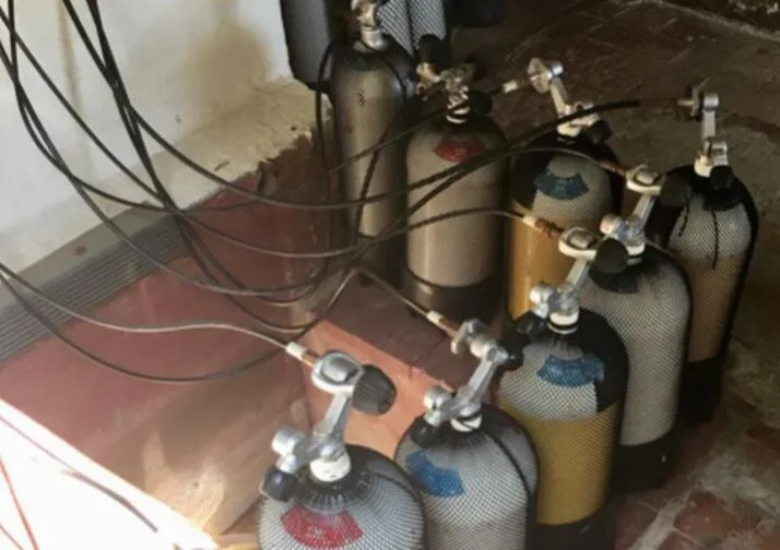 Bouteilles de plongée alignées avec détendeurs et robinets métalliques