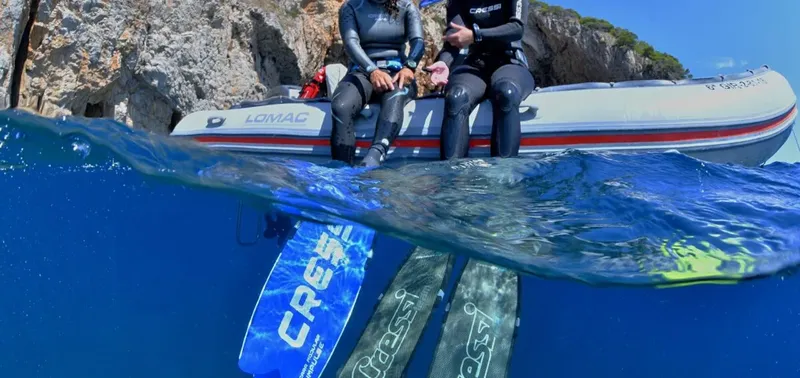 Deux plongeurs assis sur un bateau semi-rigide au large