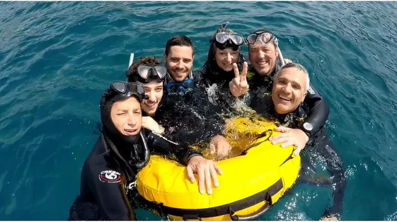 Groupe de plongeurs souriants flottant ensemble dans une eau claire
