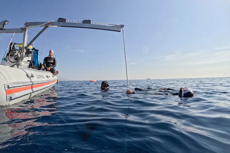 Plongeurs en apnée près d'un bateau, préparation à une descente en mer