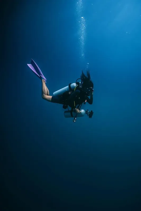 Plongeuse en scaphandre explore les profondeurs bleues de l'océan