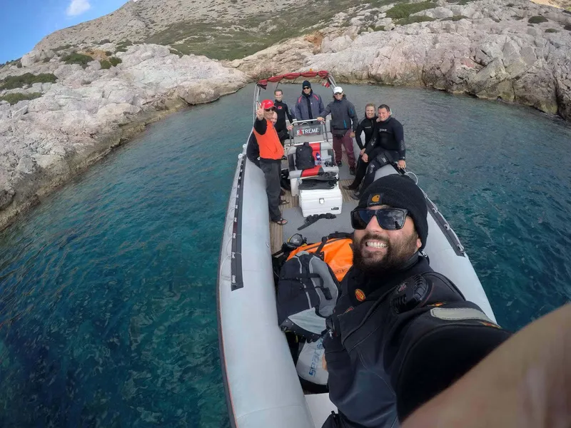 Groupe de plongeurs souriants à bord d'un bateau semi-rigide en mer