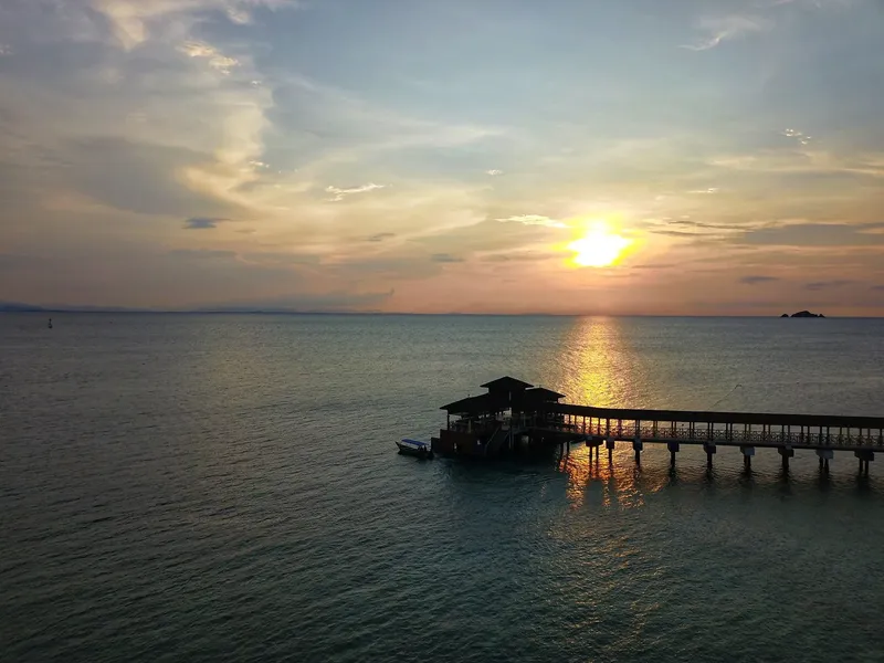 Coucher de soleil sur la mer avec ponton et petit bateau
