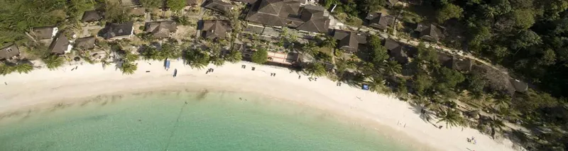 Vue aérienne d'une plage avec des bâtiments et quelques personnes