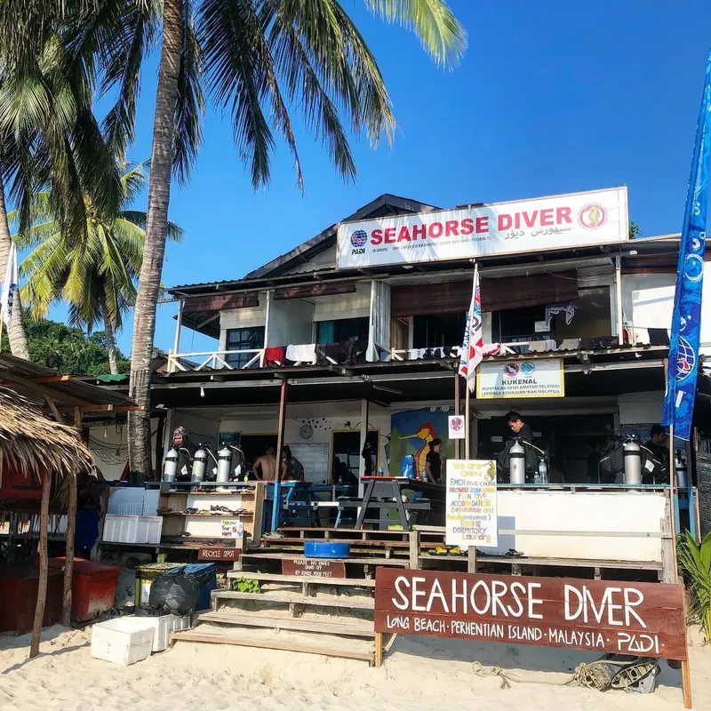 Façade d'un centre de plongée sur une plage de sable blanc