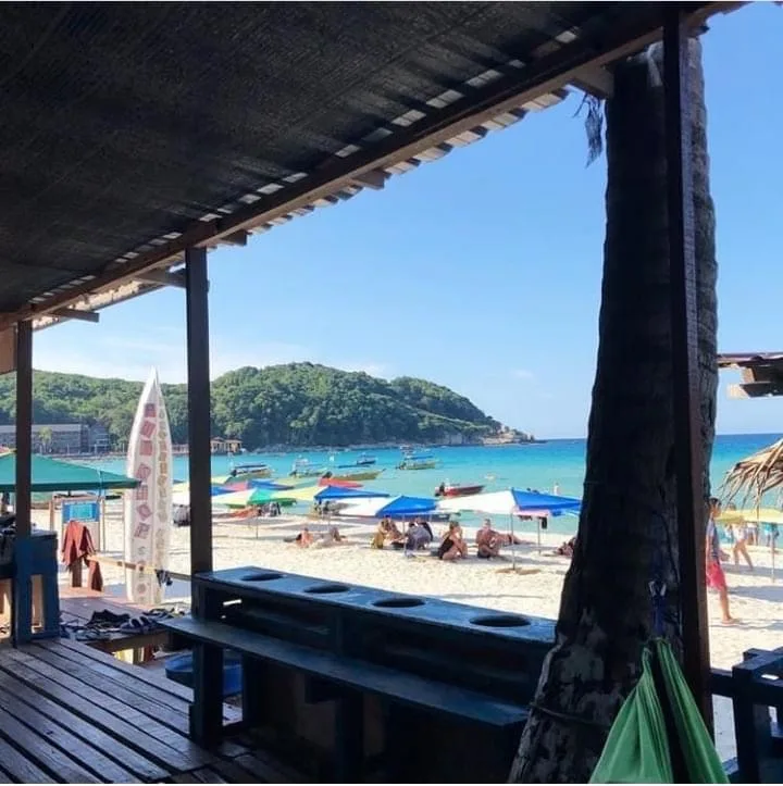 Vue sur une plage avec des bateaux et des personnes se relaxant