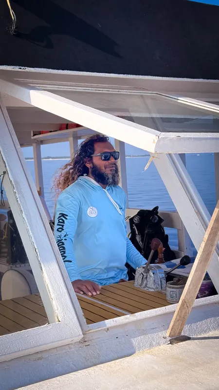 Homme barbu sur bateau de plongée avec équipement visible