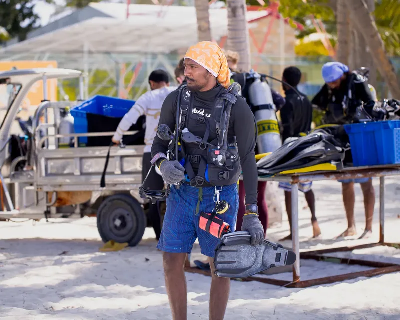 Plongeur préparant son équipement sur une plage ensoleillée