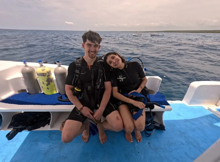 Deux plongeurs souriants sur un bateau avec du matériel
