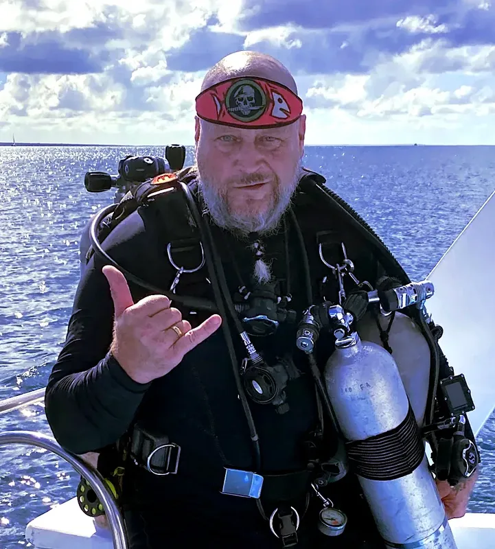 Plongeur barbu avec équipement complet sur un bateau en mer