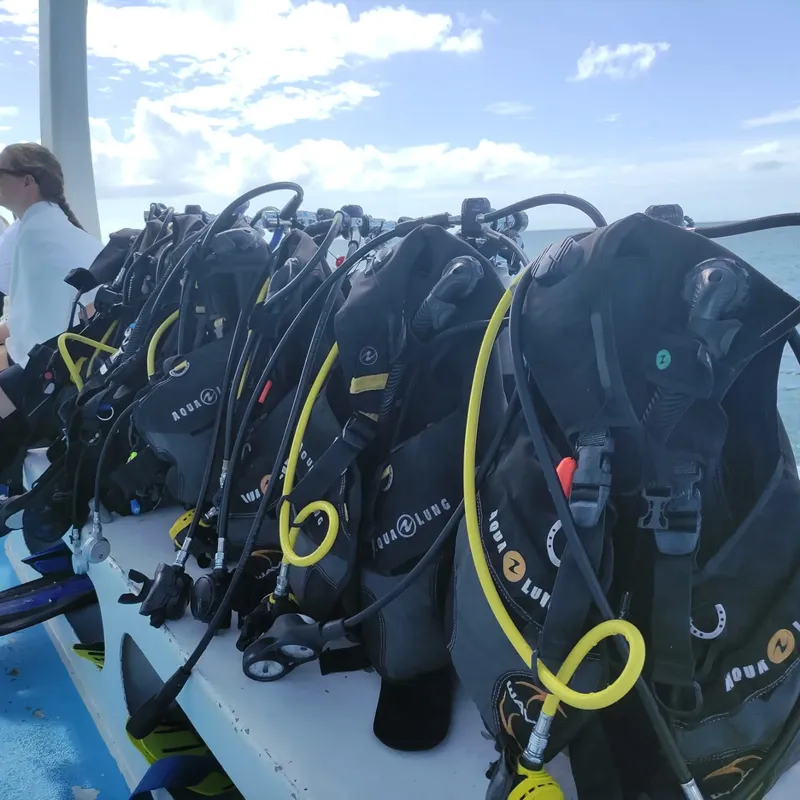 Rangées de détendeurs et gilets de plongée sur un bateau blanc