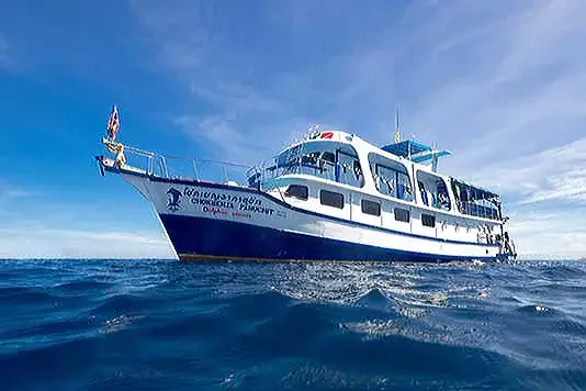 Grand bateau de plongée blanc et bleu navigue sur une mer calme