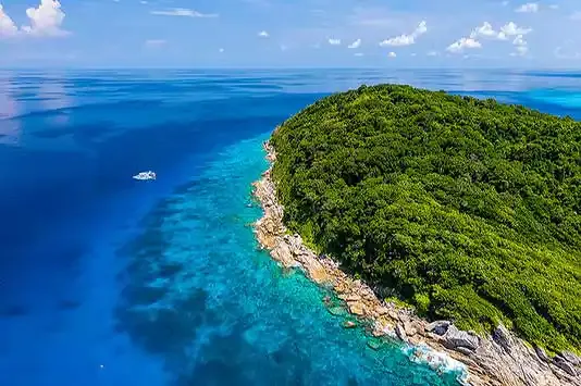 Vue aérienne d'une île tropicale avec une eau turquoise et un bateau