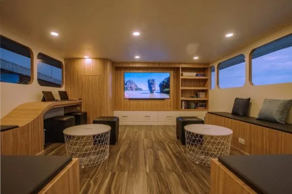 Intérieur lumineux d'un bateau avec salon, bibliothèque et écrans