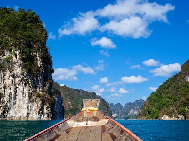 Vue depuis un bateau sur une baie avec des falaises verdoyantes