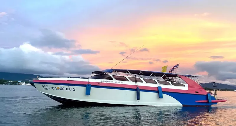 Bateau de plongée coloré sur l'eau au coucher du soleil en Thaïlande