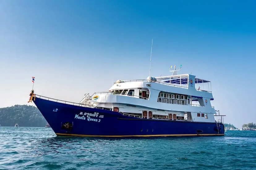Grand bateau de plongée bleu et blanc navigue sur une mer calme