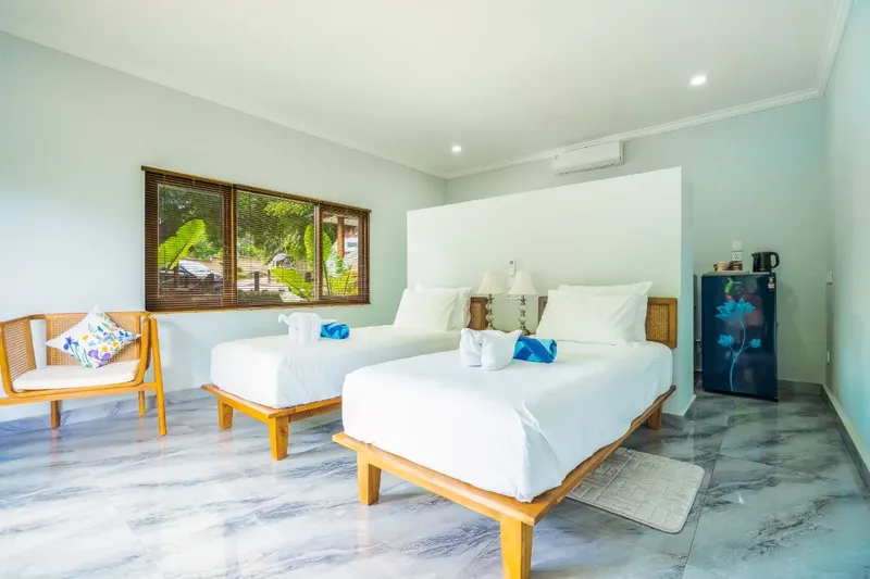 Chambre d'hôtel lumineuse avec deux lits simples et décoration sobre