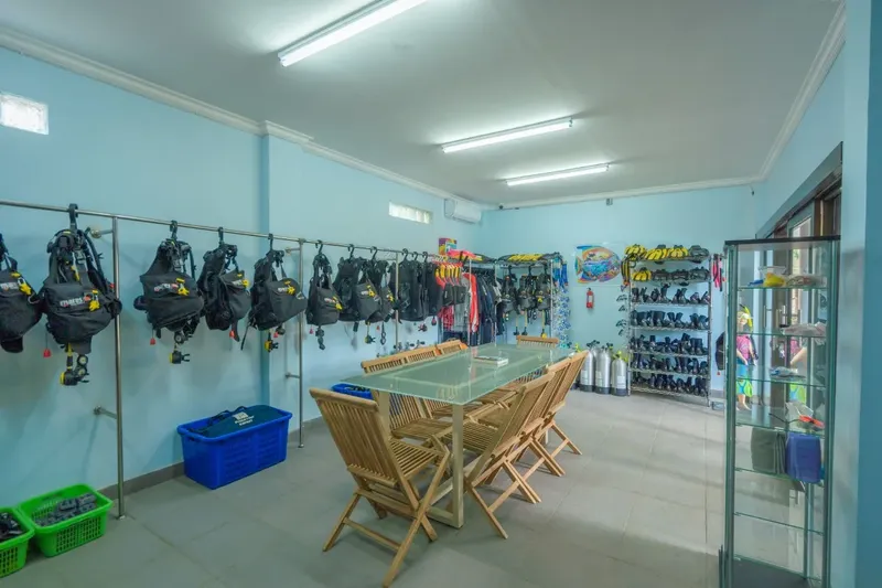 Salle de préparation plongée avec équipements, tables et bouteilles