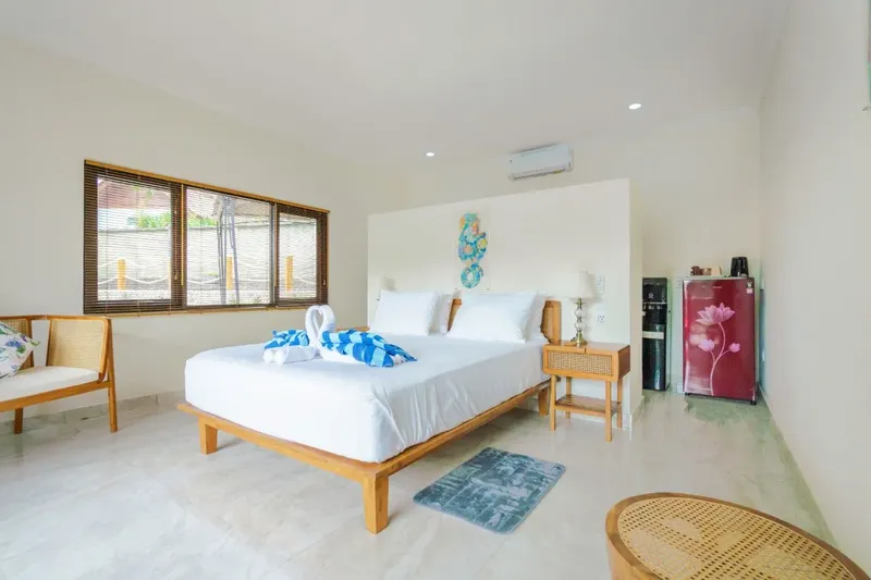Chambre d'hôtel lumineuse avec lit fait, décoration et mobilier en bois
