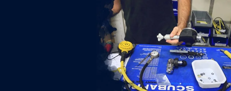 Un technicien de plongée vérifie et assemble du matériel de régulation