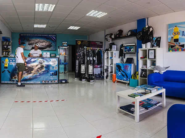 Intérieur d'un centre de plongée avec comptoir, équipement et canapé bleu