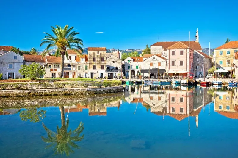 Village côtier avec bateaux amarrés dans un port calme et ensoleillé