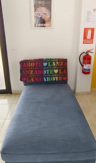 Canapé bleu dans un espace d'attente avec affiche et extincteur