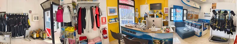 Intérieur d'un centre de plongée avec matériel, comptoir d'accueil et combinaisons