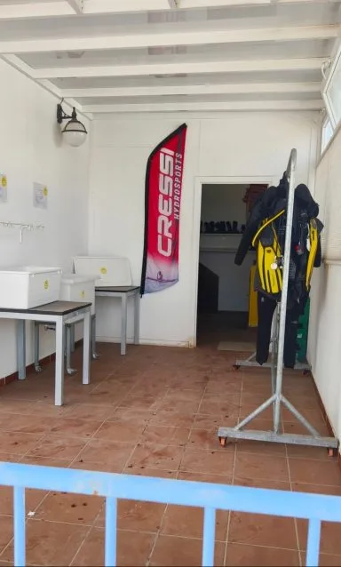 Intérieur d'un local de plongée avec matériel et drapeau Cressi