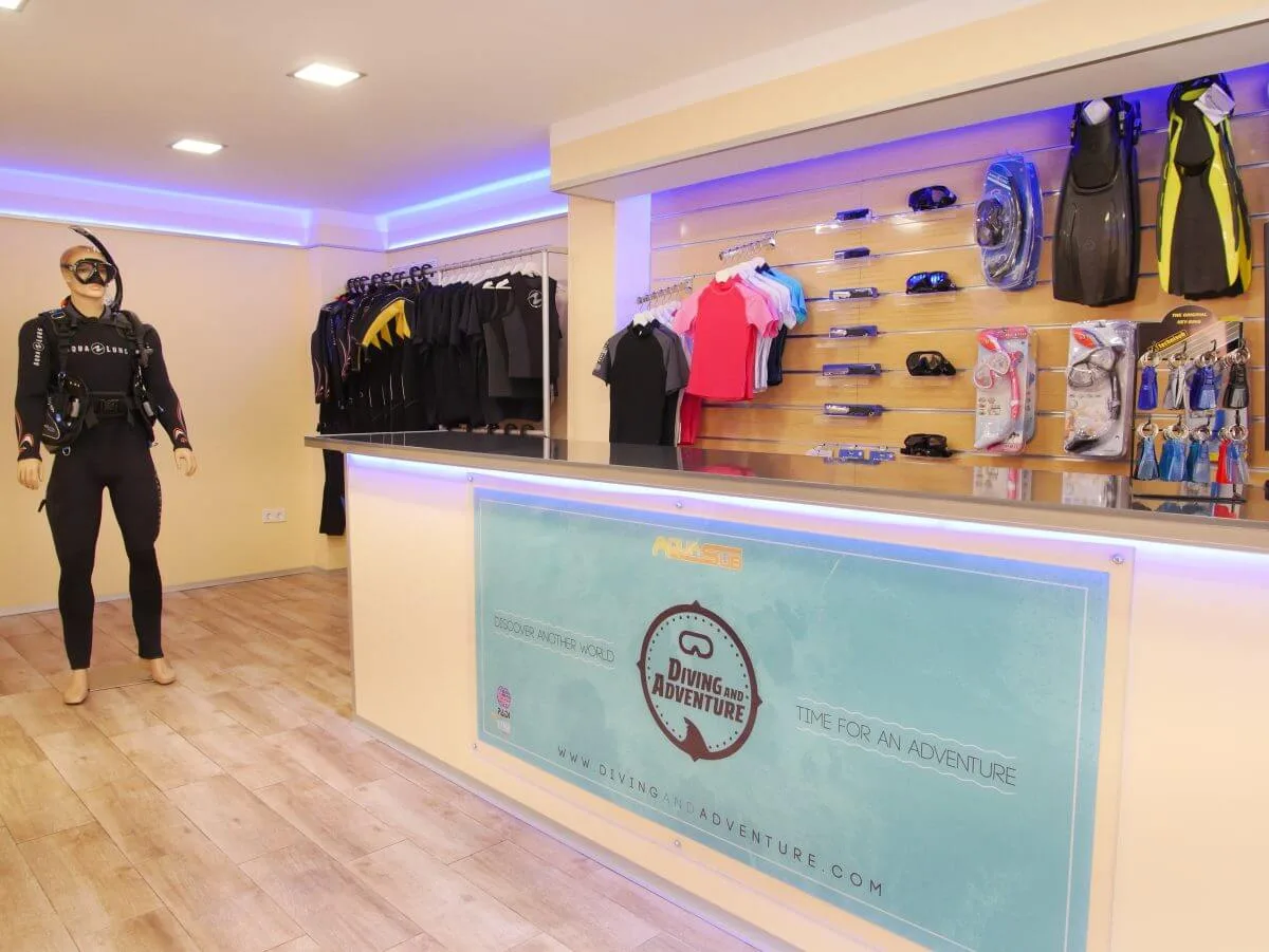 Intérieur d'un centre de plongée avec comptoir, équipement et personne