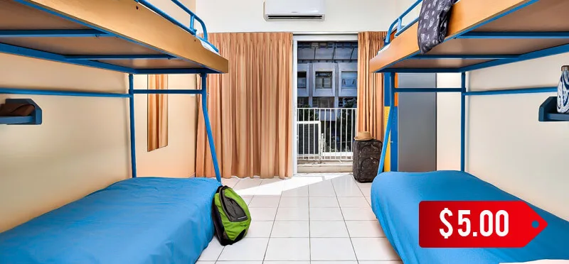 Dortoir avec lits superposés, sac à dos et prix affiché