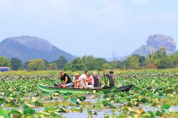 Groupe de personnes naviguant sur un lac avec végétation luxuriante