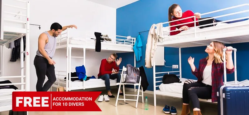 Dortoir avec lits superposés et personnes préparant leurs affaires