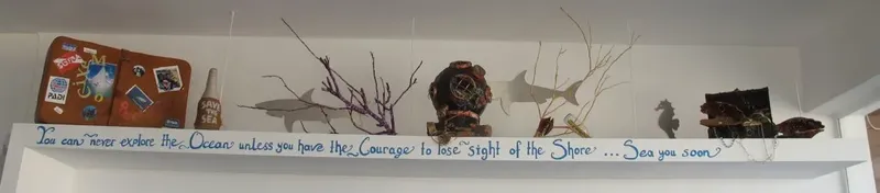 Étagère décorative avec sac de plongée, bouteille et inscription inspirante