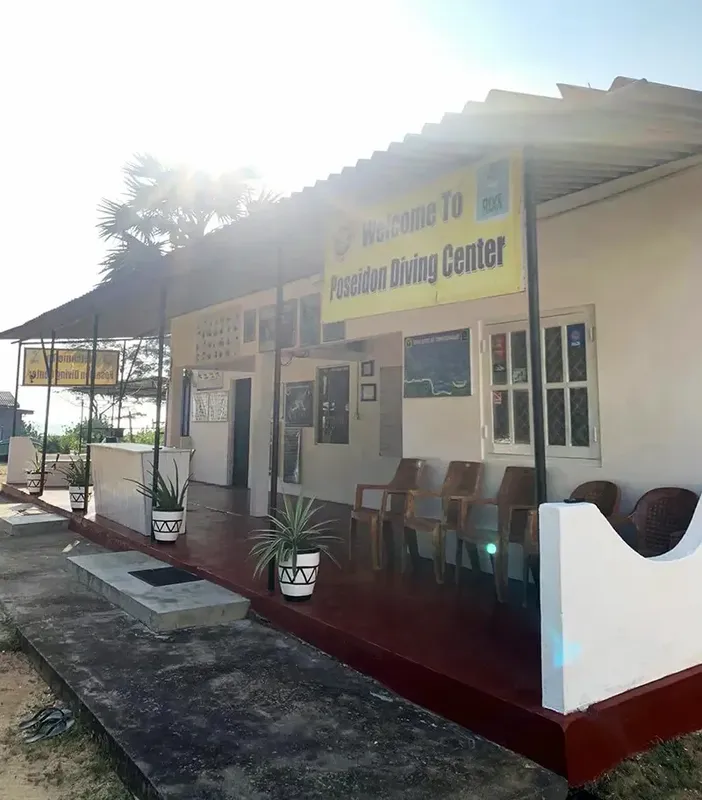 Façade d'un centre de plongée avec une terrasse et végétation tropicale