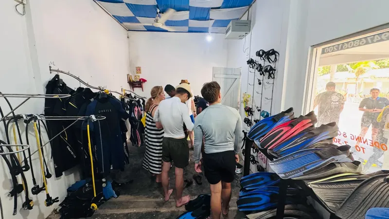Intérieur d'un centre de plongée avec des clients et du matériel
