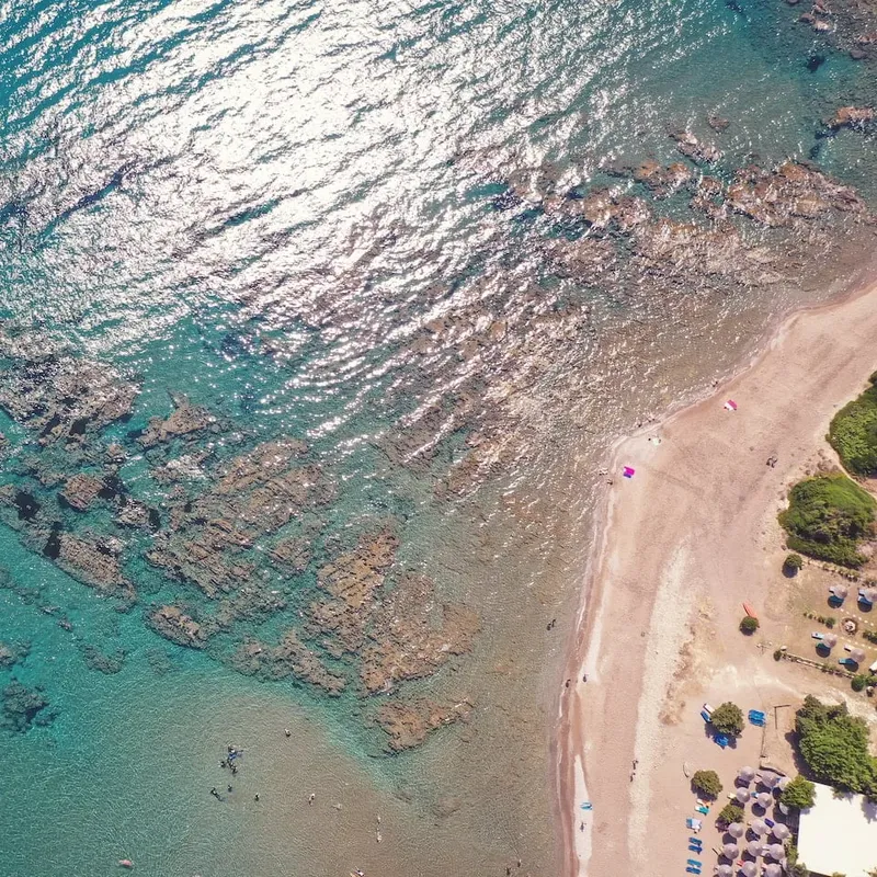Vue aérienne d'une plage avec des baigneurs et quelques bateaux